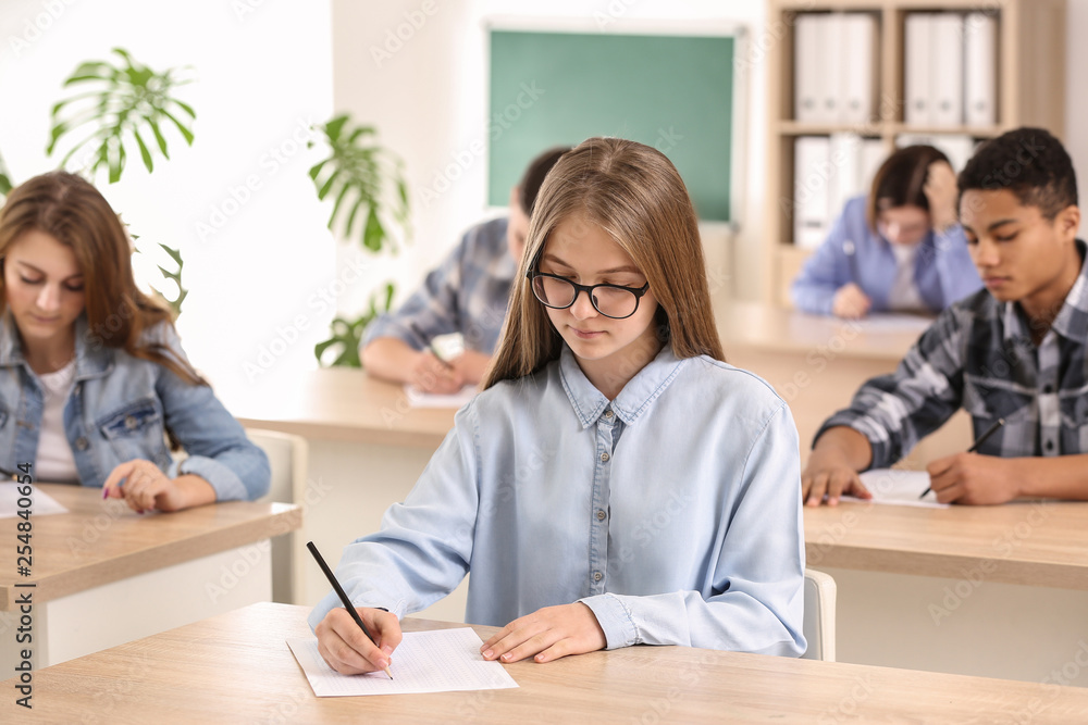 Pupils passing school test in classroom Pupils passing school test in classroom