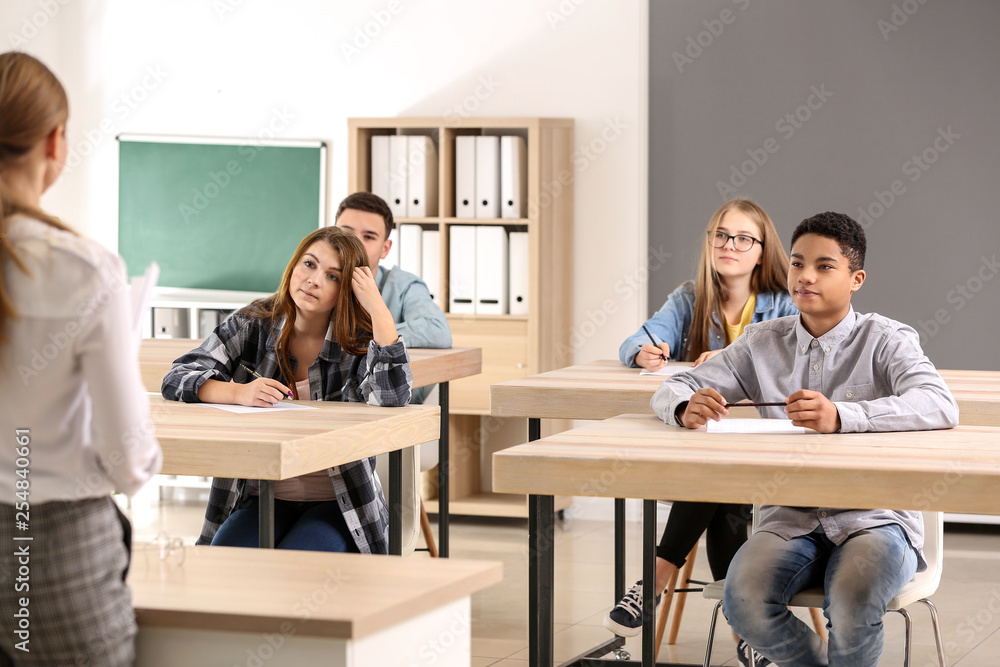 Pupils passing school test in classroom Pupils passing school test in classroom