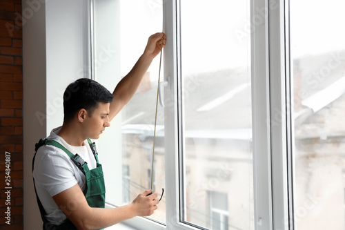 Male worker taking measurements of window in flat Free Download Male worker taking measurements of window in flat - GFXLoad