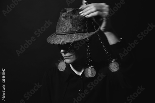 Photos Female hypnotist with swinging pendulum on dark background