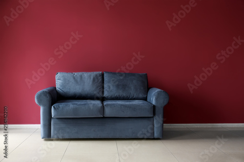 Comfortable sofa near color wall