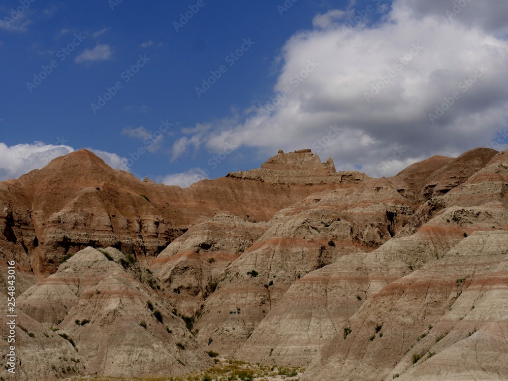 Fototapeta premium Medium close up of the dramatic mountaintops at Badlands National Park in South Dakota, USA, with gorgeous clouds in the skies.