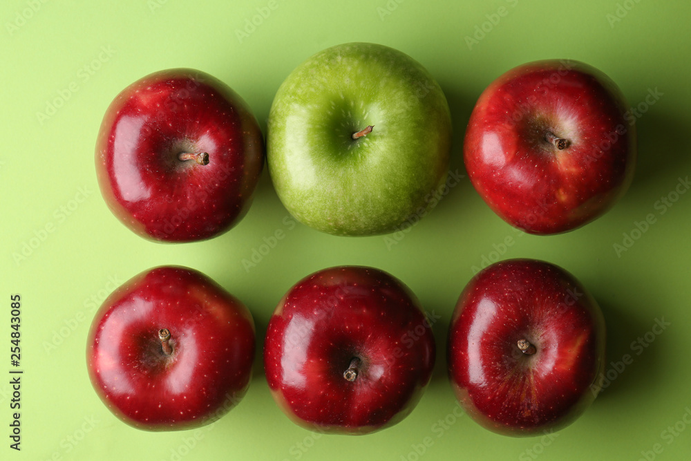 Green apple among red ones on color background. Concept of uniqueness Green apple among red ones on color background. Concept of uniqueness