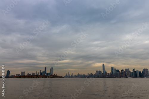 View of New York City skyline with dramatic sky at dusk from Liberty Island, New York, USA © Andrew Davidson