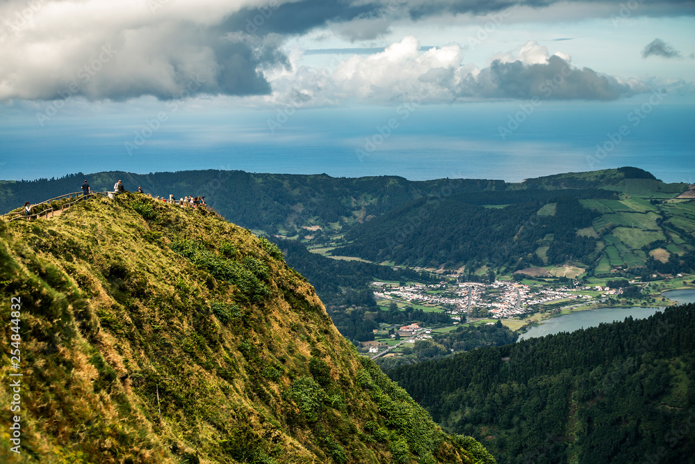 Beautiful lansdcape of Azores island, Sao Miguel. You can see the rock on foreground and city on background. Cloudy sky.