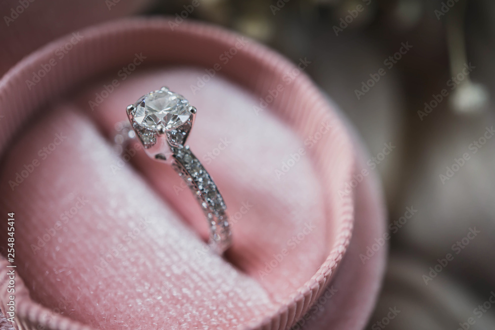 Fototapeta premium Close up of an elegant diamond ring in pink box. soft and selective focus. Love and wedding concept.