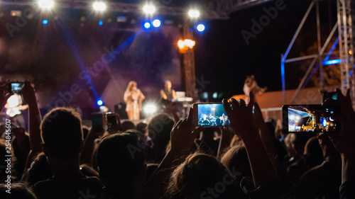 Spectators of the concert are filmed on phones