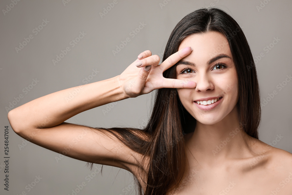Portrait of beautiful woman with healthy skin on grey background Portrait of beautiful woman with healthy skin on grey background