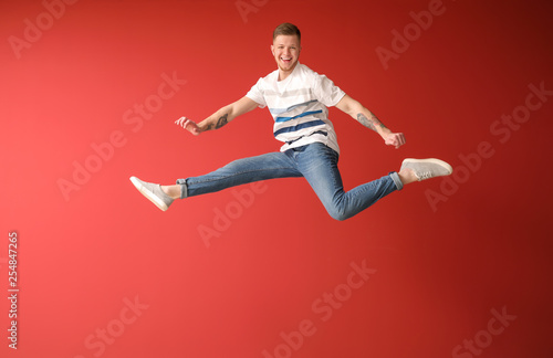 Handsome jumping man against color background