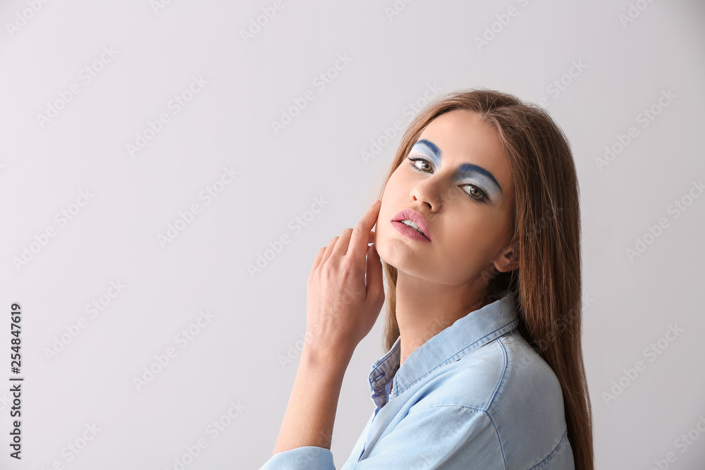 Beautiful young woman with bright makeup on light background Beautiful young woman with bright makeup on light background