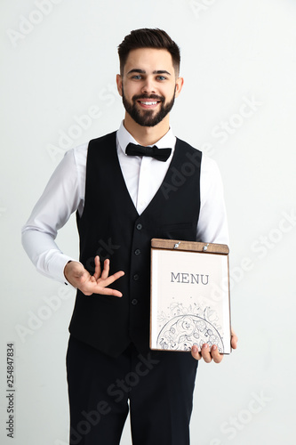 Waiter with menu on light b...