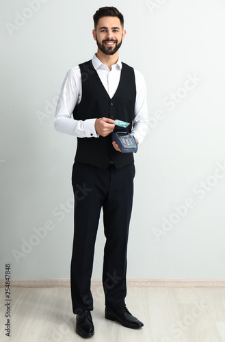 Handsome waiter with paymen...