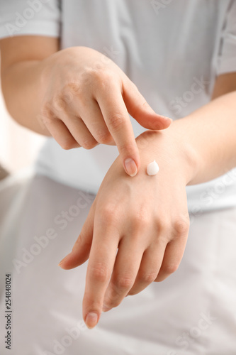 Young woman applying hand cream, closeup