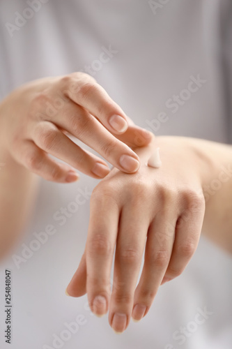 Fototapeta Naklejka Na Ścianę i Meble -  Young woman applying hand cream, closeup