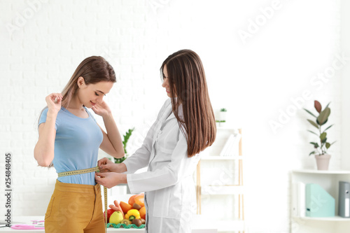 Nutritionist measuring wais...