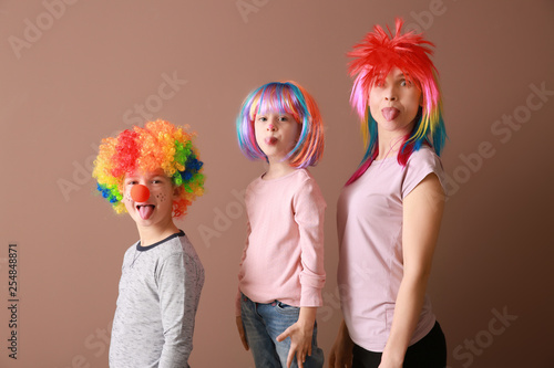 Family in funny disguise on color background. April fools' day celebration