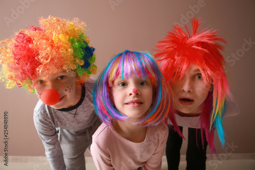 Family in funny disguise on color background. April fools  day celebration
