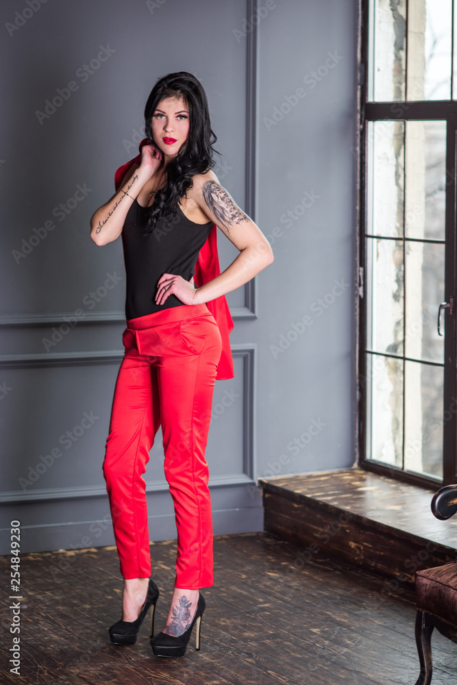 Brunette woman in red suit. Fashionable sensual modern look, pretty  business style Stock Photo