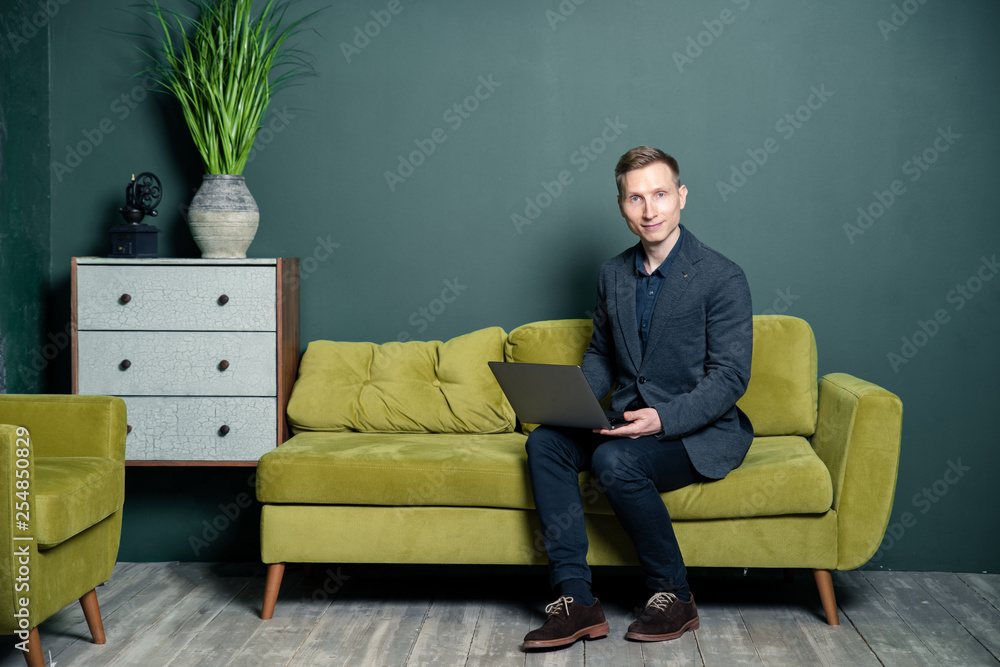 Fototapeta premium young man sitting on sofa and watching tv