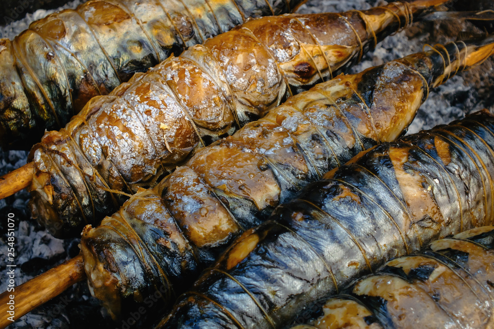 Barbecue, grill, kebab. Mackerel fish strung on wooden sticks and tied with string. Barbecue, grill, kebab. Mackerel fish strung on wooden sticks and tied with string.