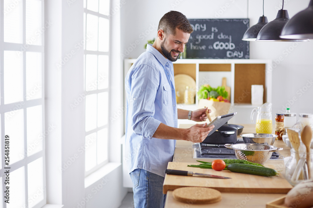 Smiling and confident chef standing in large kitchen Smiling and confident chef standing in large kitchen