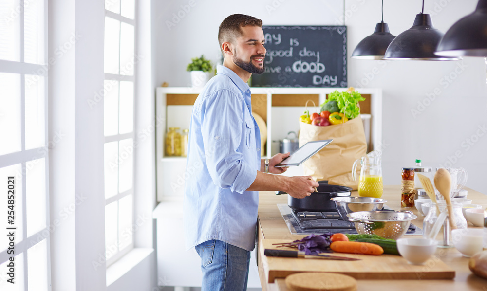 Smiling and confident chef standing in large kitchen Smiling and confident chef standing in large kitchen