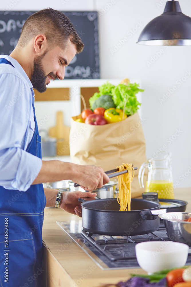 Smiling and confident chef standing in large kitchen Smiling and confident chef standing in large kitchen