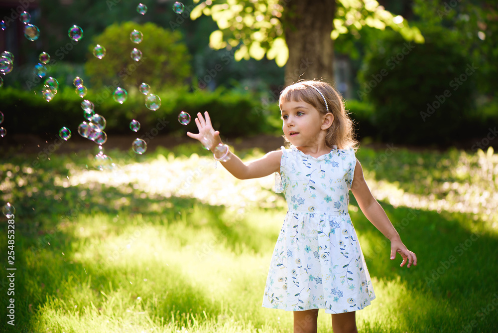 Happy baby girl standing in grass with dandelions Happy baby girl standing in grass with dandelions