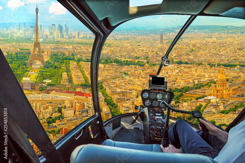 Helicopter cockpit flying on Panorama of Tour Eiffel and national residence of the Invalids in Paris, French capital, Europe. Scenic flight above Paris skyline and cityscape background.