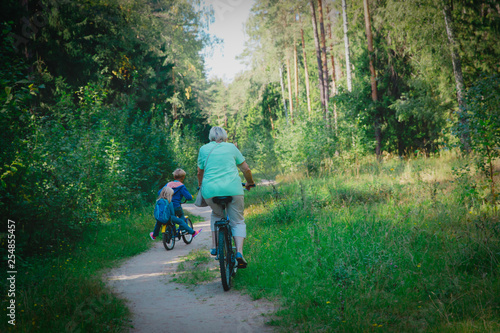 active senior grandmother with kids riding bikes in nature