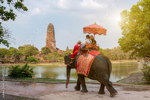 Tourists on an ride elephant tour of the ancient city in background