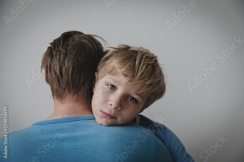 Father comforting sad child, stressed son hug dad