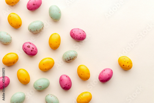 Sticker Easter chocolate eggs candy on a pastel yellow background, creative flat lay eas