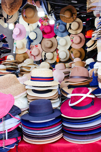 Colorful multicolored stacks of summer hats for sale at the night street market