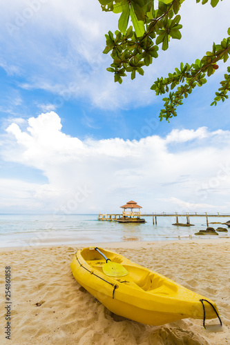 Yellow kayak boat on white sand beach