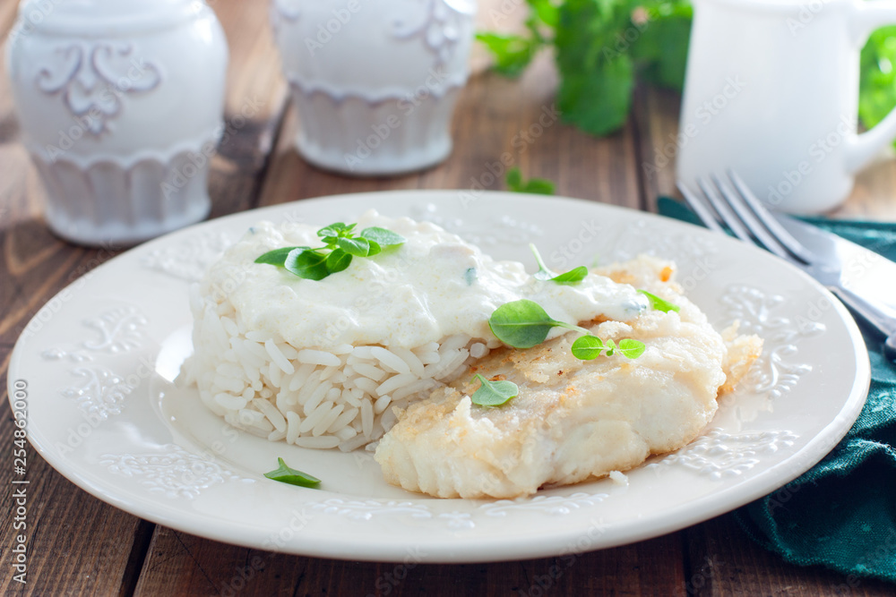 Fried cod, cooked with rice and cream sauce, horizontal Fried cod, cooked with rice and cream sauce, horizontal