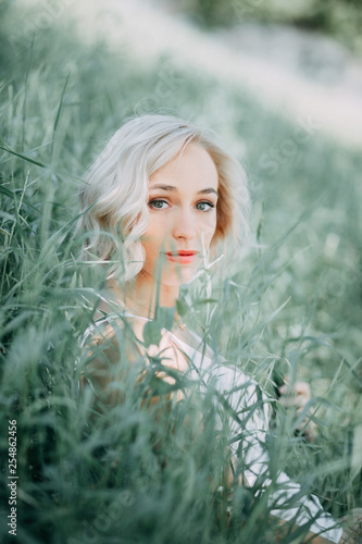 Fototapeta Naklejka Na Ścianę i Meble -  Blonde girl in the green grass