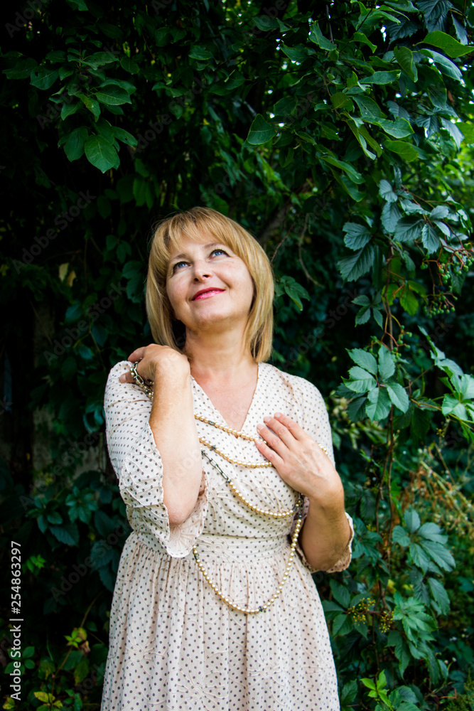 Portrait of happy beautiful blonde woman with pearls in summer park Portrait of happy beautiful blonde woman with pearls in summer park