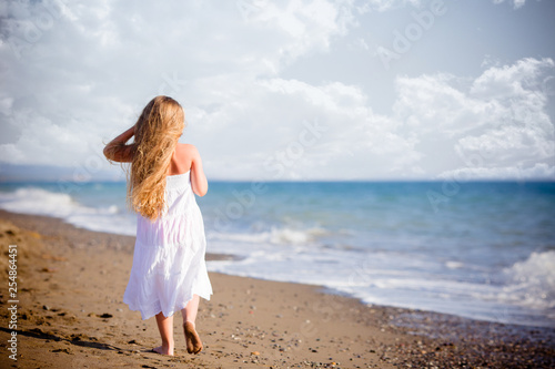 Bambina felice sulla riva del mare