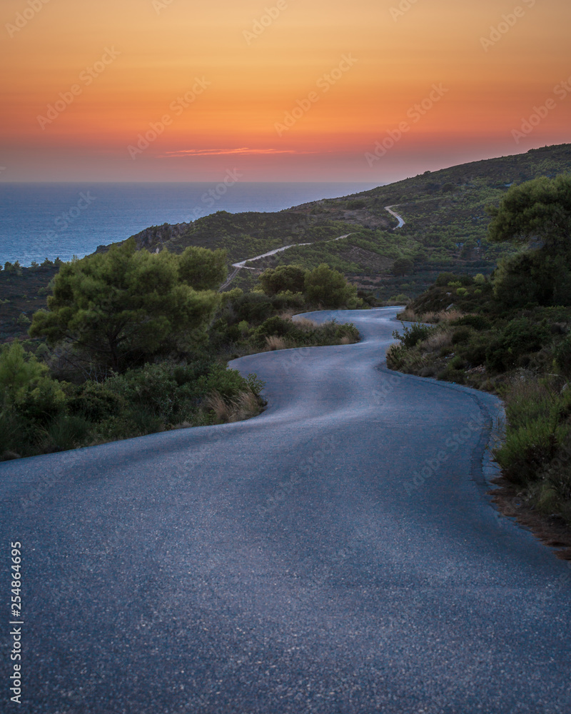Sunset in Zante greece on the north west coast, long and winding road with great colours showing the horizon.