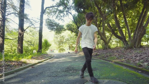 Drunk Intoxicated Young Asian Man Staggering Around While Walking on Path in Park
