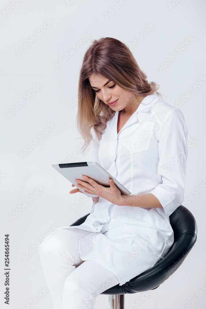 Portrait of beautiful blonde doctor in white coat working on digital tablet Portrait of beautiful blonde doctor in white coat working on digital tablet