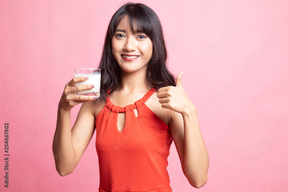 Healthy Asian woman drinking a glass of milk thumbs up. Healthy Asian woman drinking a glass of milk thumbs up.