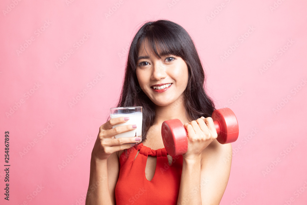 Healthy Asian woman drinking a glass of milk and dumbbell. Healthy Asian woman drinking a glass of milk and dumbbell.