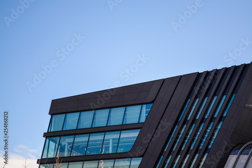 Modern and unusual architecture from metal and glass. Non-standard forms and decisions. Lines and geometry of the big building. 