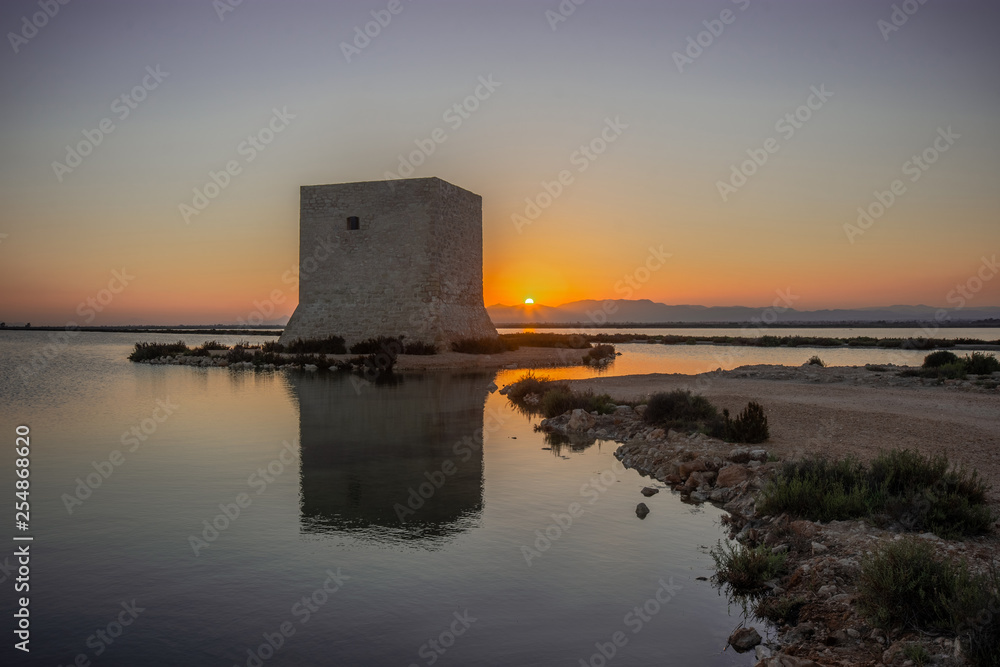 Antigua torre en medio de la marisma de Santa Pola al atardecer, Costa Blanca, Alicante, Comunidad Valenciana, España.