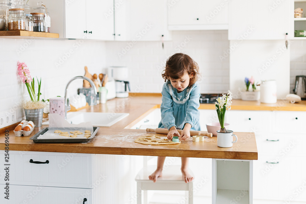 Little girl preparing easter cookies at the kitchen. Little girl preparing easter cookies at the kitchen.