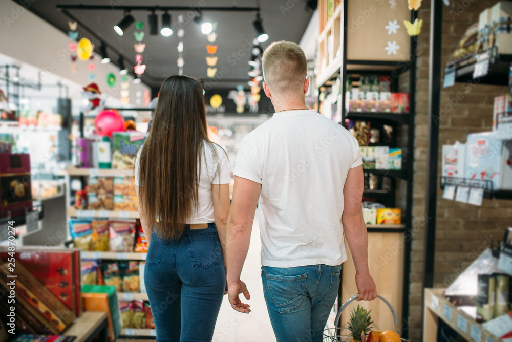 Young couple in food supermarket, back view