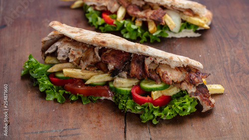 Gyros, shawarma, take away, street food. Sandwich with meat on wooden table