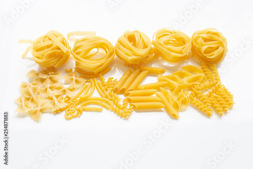 Different types of dry pasta on white.